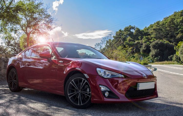 Roter Toyota am Straßenrand in der Sonne