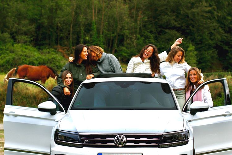 Happy girls in front of car